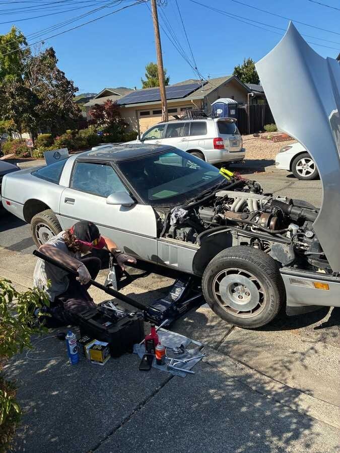 Hands-on mobile service on a silver Corvette